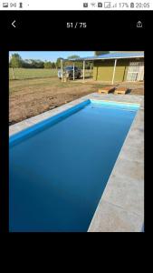 圣安东尼奥德阿雷科El retiro, casa de campo的房子前面的蓝色游泳池