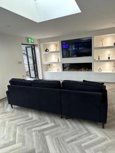 利物浦128 Anfield Road的客厅配有黑色沙发和平面电视。