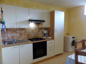 Saint-PalaisAppartement Saint-Palais (Allier), 3 pièces, 6 personnes - FR-1-489-418的厨房配有白色橱柜和炉灶烤箱。