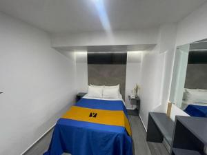 韦拉克鲁斯Hotel GALENO的一间小卧室,配有黄色和蓝色的床