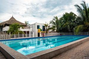 托卢Caribbean Town Tolu的一个带白色围栏和棕榈树的游泳池