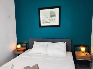 威廉斯塔德Saint Joris a tiny Boutique Resort的一间卧室设有蓝色的墙壁和一张带两盏灯的床。