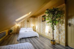 伦敦Lux Versace Pad Sleeps 10 Hot Tub, Cinema & Games Room的一间卧室配有一张床和盆栽植物