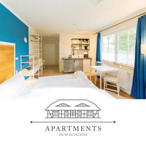 梅伦新~ Apartments zum Schloss ~ Traumhafte Ferienwohnungen auf Usedom的一间带一张床和一张书桌的卧室和一间厨房