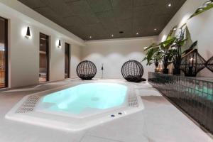 瓦雷尔Hotel Friesenhof的植物间的大浴缸