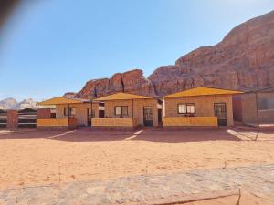 瓦迪拉姆Bedouin picnic camp的沙漠中的一座建筑,背景是一座山