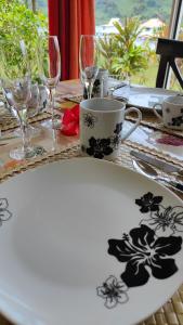 TivaTIVA PERL LODGE TAHAA的一张桌子,上面有黑色花卉的白色盘子