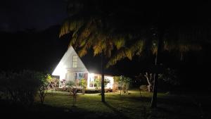 TivaTIVA PERL LODGE TAHAA的夜晚在房子的一侧有灯
