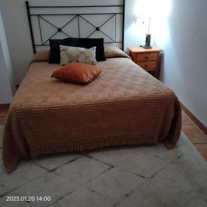 拉洛勒斯Apartamento vacacional en la Alpujarra的一间卧室配有一张带橙色枕头的床