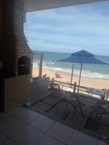 里约达欧特拉斯Casa de Praia PÉ NA AREIA em Rio das Ostras RJ的一个带遮阳伞和椅子的庭院和一个海滩
