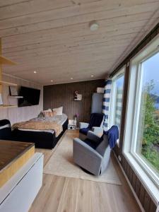 苏特兰Sjarmerende anneks i Sigerfjord, Vesterålen的一间卧室配有一张床、一张床和一把椅子