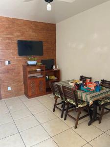 里约达欧特拉斯Casa de Praia PÉ NA AREIA em Rio das Ostras RJ的客厅配有桌椅和电视。