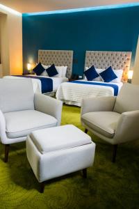 普埃布拉HOTEL MARGARITA的酒店客房,配有两张床和两把椅子