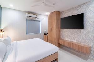 海得拉巴Harvey's Hotels (Gachibowli)的一间卧室配有一张床和一台平面电视