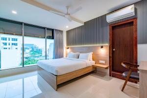 海得拉巴Harvey's Hotels (Gachibowli)的一间卧室配有一张床、一张书桌和一个窗户。