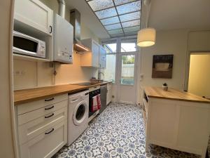 亚眠Maison de Charme - 4 Chambres - Courette & Parking Gratuit的厨房配有洗衣机和烘干机