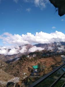 巴德里纳特Badrinath Dharmshala by Prithvi Yatra Hotel的背景云的山峰景
