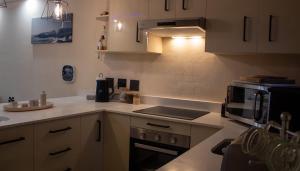 布鲁堡史特兰Seacret Whale的厨房配有微波炉和炉灶。 顶部烤箱