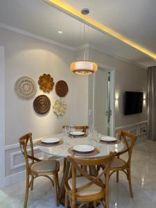 福塔莱萨Flat Beira Mar的一间配备有白色桌椅的用餐室