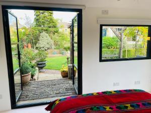 法纳姆High spec studio cabin-Farnham centre的卧室设有窗户,享有花园的景色