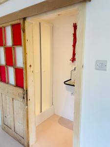 法纳姆High spec studio cabin-Farnham centre的一间房间,墙上有一扇门和十字架