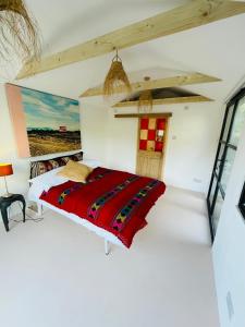 法纳姆High spec studio cabin-Farnham centre的一间卧室配有一张带红色毯子的床