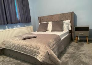 切森特Cheshunt Hertfordshire 4 bed的一间卧室配有一张床和一个床头柜