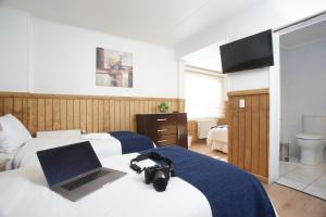 蓬塔阿雷纳斯西罗苏尔旅馆的酒店客房设有两张床、一台笔记本电脑和一台摄像机