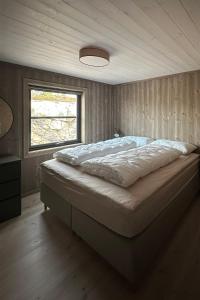 DrangedalHelårs moderne familiehytte med wifi, billader, ski inn, ski ut og utmerket beliggenhet的卧室内的一张大床,设有窗户