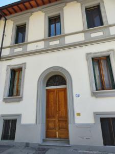 佛罗伦萨Affittacamere Ramazzini的白色的建筑,设有木门和窗户