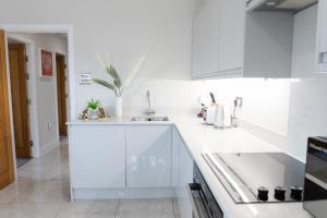 卡迪夫Luxury Cardiff City Centre Apartments的白色的厨房设有水槽和台面