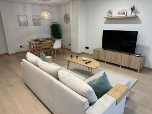 维戈Move in Miragaia的带沙发、电视和桌子的客厅