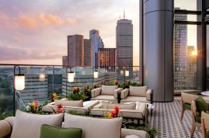 波士顿Raffles Boston的带沙发的屋顶露台,享有城市美景