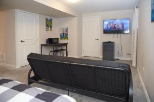 渥太华Fully Furnished En-Suite Basement的一间房间,配有一张床和墙上的电视