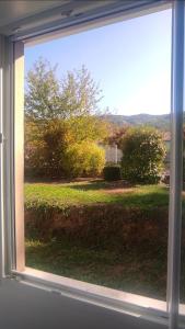 塔拉尔Chambre chez l'habitant "Entre Airs et Montagnes"的享有草地景致的窗户