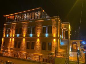 格雷梅Rustic Caves Hotel的一座大型砖砌建筑,晚上有灯