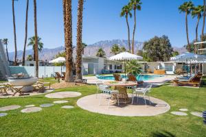 棕榈泉Monkey Tree Hotel by AvantStay Stylish Hotel in Palm Springs w Pool的一个带桌椅的庭院和一个游泳池