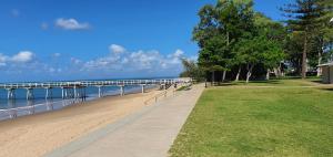 赫维湾Villa Venezia Apt 3 - Spacious Hervey Bay beachfront apartment的海滩旁的步行道,设有码头