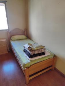 安东尼奥港Alma Patagona Hostel的一张小床,位于客房的角落
