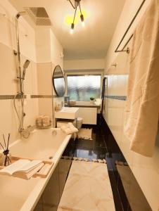 因戈尔施塔特Stilvolle 3-Zimmer Wohnung in Ingolstadt mit Balkon und guter Autobahnanbindung的带浴缸、水槽和镜子的浴室