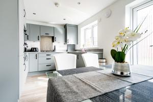 GreenhitheTHE LAKE - A stunning 2 bedroom house, only 17mins to Central London!!!的厨房以及带桌椅的用餐室。