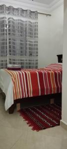 沃利迪耶Dar Malaika的一张位于一间红色和白色毯子的房间的床铺