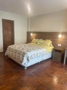 利马FLAT AMOBLADO EN PUEBLO LIBRE - LIMA - PERÚ的一间卧室配有一张大床和木制床头板