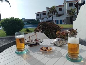 洛思坎加约斯Casa Lago Azul 49的两杯啤酒和一碗桌上的食物