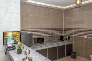 达赫拉Palm D'or-Appartement familial de luxe au centre de Dakhla的浴室配有水槽和带微波炉的台面。