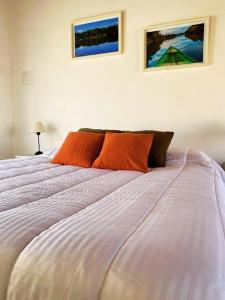 梅赛德斯Duplex Reencuentro的一间卧室配有一张带橙色枕头的大床
