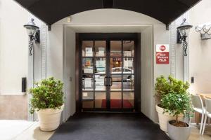 纽约贝斯特韦斯特款待套房酒店的前方有两株盆栽植物的建筑物的门