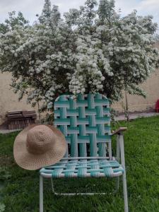 迈普Maipú soñado的坐在树前椅子上的草帽