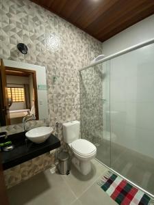 皮雷诺波利斯Pousada Portal do Cerrado的浴室配有卫生间、盥洗盆和淋浴。