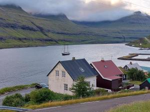 FunningsfjørðurFjord Guesthouse的水体边的房子